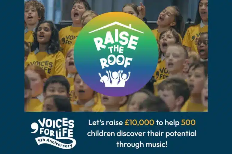 "Promotional image for Voices for Life’s 'Raise the Roof' campaign. A group of children in yellow 'Voices for Life' shirts are singing together. In the center is a colorful circular logo with the text 'RAISE THE ROOF' and an illustration of three people raising their hands under a roof. Below, text reads: 'Let's raise £10,000 to help 500 children discover their potential through music!' A 'Voices for Life 5th Anniversary' logo appears in the bottom left corner.