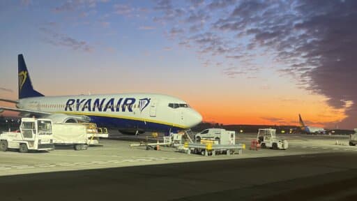 A picture of a Ryanair passenger jet on a runway with the sun setting in the background — Bristol Airport