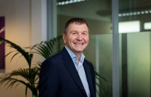 Simon Holdsworth of Thrings smiling and wearing an open-necked blue shirt and smart jacket